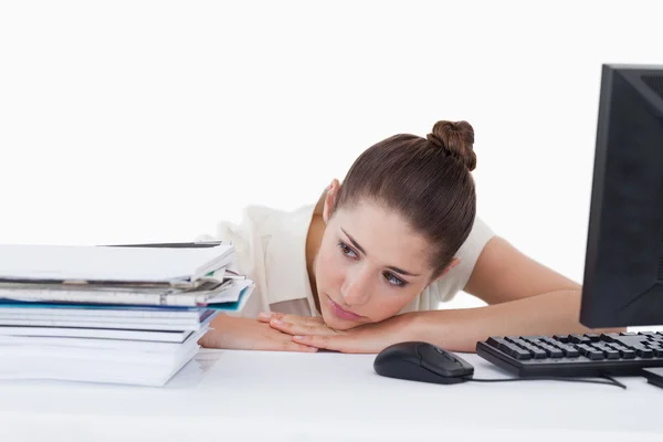 Tired secretary leaning on her desk — Stock Photo, Image