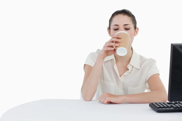 Бізнес-леді п'є чай на винос при використанні комп'ютера — стокове фото