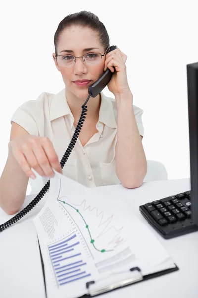 Portrait of a manager making a phone call while looking at stati — Stock Photo, Image