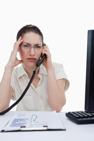 Portrait of a tired manager making a phone call while looking at — Stock Photo, Image