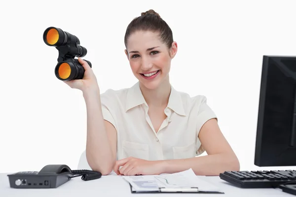Smiling businesswoman holding binoculars — Stock Photo, Image