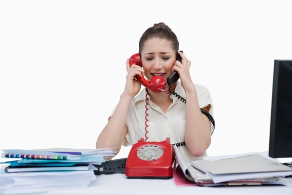 Secretária stressada a atender os telefones — Fotografia de Stock