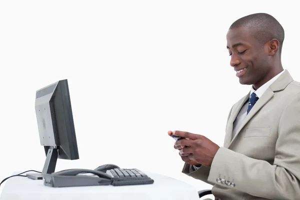 Vista lateral de um empresário sorridente enviando uma mensagem de texto — Fotografia de Stock