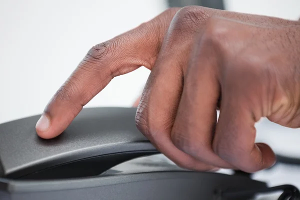 Close up of a masculine hand on a phone handset — Stock Photo, Image