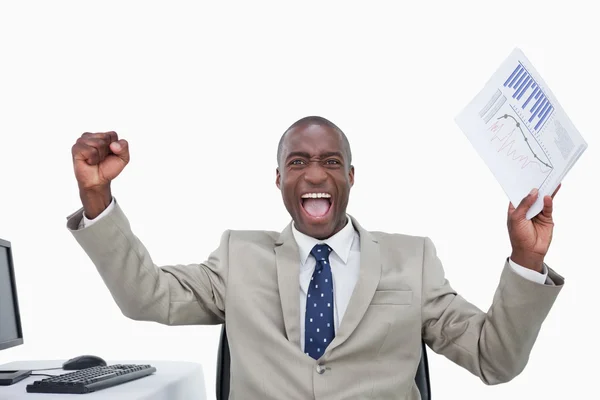 Victorious salesman with the fists up while holding a graph — Stock Photo, Image
