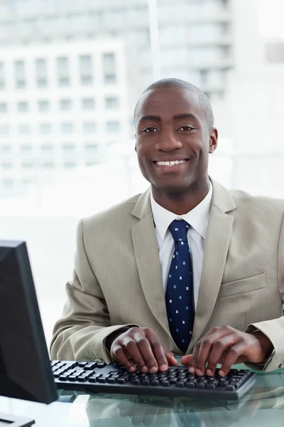 Portret van een vrolijke kantoor werknemer met behulp van een computer — Stockfoto