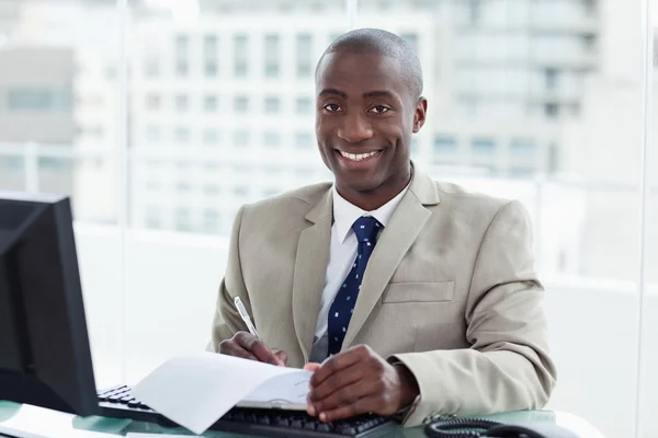 Empreendedor sorridente assinando um documento — Fotografia de Stock
