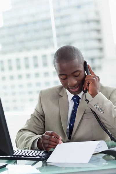 Portret van een ondernemer waardoor een telefoongesprek tijdens het lezen een — Stockfoto