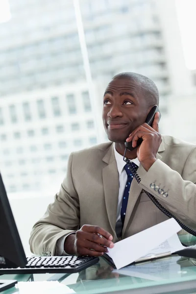 Portrait of a happy entrepreneur making a phone call while readi — Stock Photo, Image