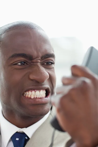 Retrato de um empresário furioso olhando para o seu telefone aparelho — Fotografia de Stock