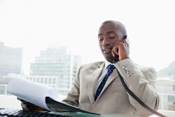 A telefon egy dokumentum olvasása közben üzletember — Stock Fotó