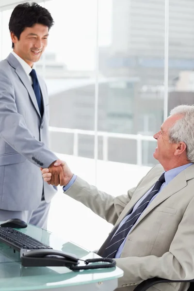 अपने प्रबंधक का हाथ हिलाते हुए एक मुस्कुराते हुए कर्मचारी का चित्र — स्टॉक फ़ोटो, इमेज