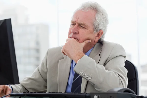 Focused senior manager working with a monitor — Stock Photo, Image