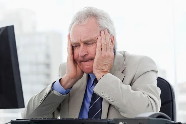 Upset senior manager working with a monitor — Stock Photo, Image