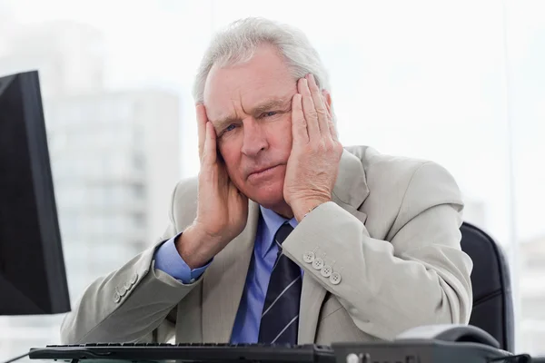 Tired senior manager working with a monitor — Stock Photo, Image