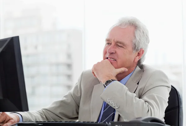 Happy senior manager working with a monitor — Stock Photo, Image