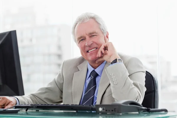 Smiling senior manager working with a monitor — Stock Photo, Image