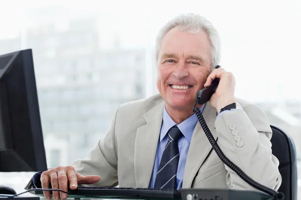 Улыбающийся старший менеджер по телефону — стоковое фото