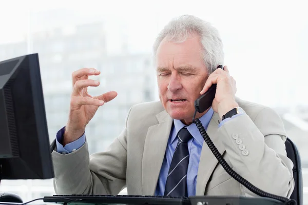 Раздраженный старший менеджер по телефону — стоковое фото