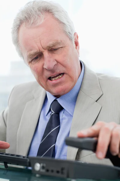 Portrait of an angry senior manager hanging up — Stock Photo, Image