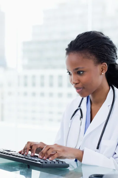 Portrait d'une femme médecin sérieuse utilisant un ordinateur — Photo