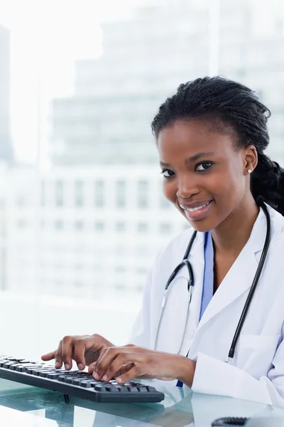 Portrait of a smiling female doctor using a computer — Stock Photo, Image