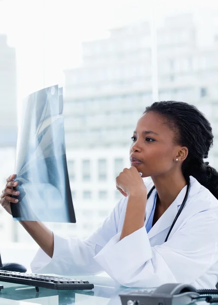 Portrét ženského lékaře při pohledu na řadu snímky — Stock fotografie