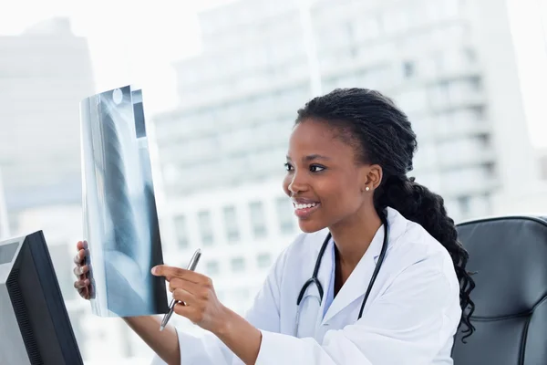 Gelukkig vrouwelijke arts kijken naar een set van x-stralen — Stockfoto