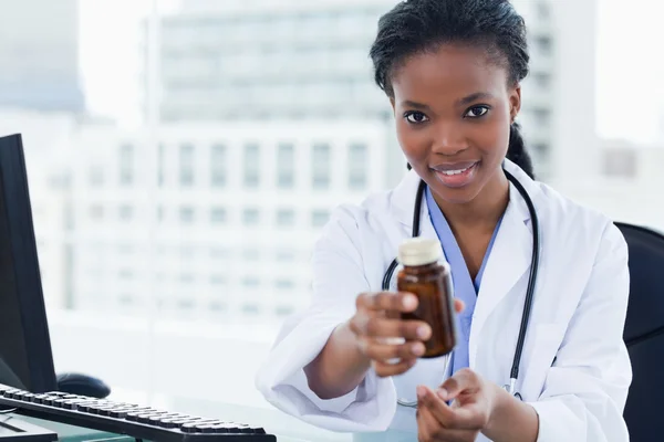 Young female doctor giving medication — Stock Photo, Image