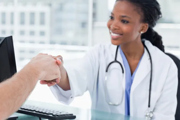 Uśmiechnięta kobieta lekarz drżenie ręki — Zdjęcie stockowe