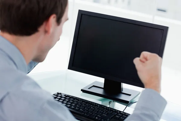 Vista posteriore di un uomo d'affari che lavora con un computer con il pugno — Foto Stock