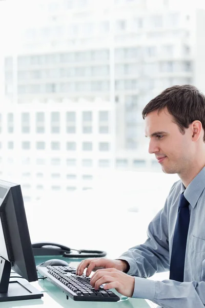 Vista lateral de um trabalhador de escritório usando um monitor — Fotografia de Stock