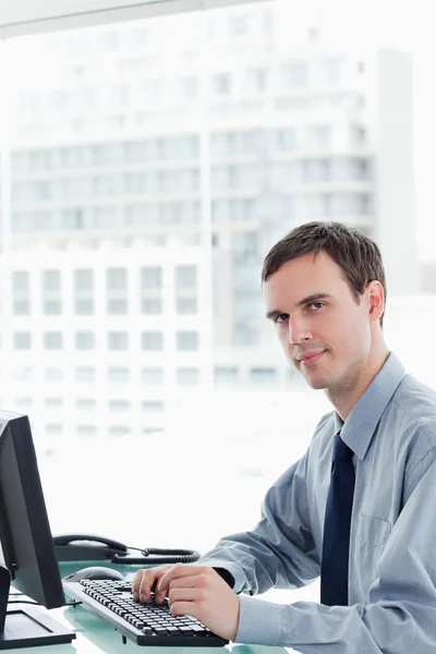 Zijaanzicht van een ernstige kantoor werknemer met behulp van een monitor — Stockfoto