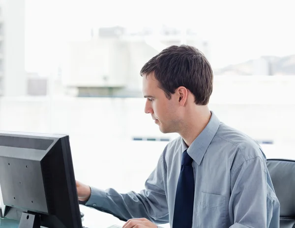 Trabalhador de escritório sério usando um monitor — Fotografia de Stock