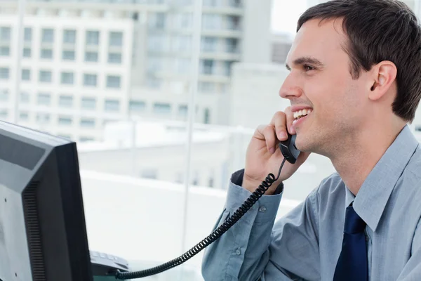 Lächelnde Büroangestellte am Telefon — Stockfoto
