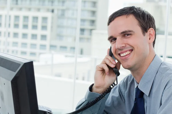 Zufriedene Büroangestellte am Telefon — Stockfoto