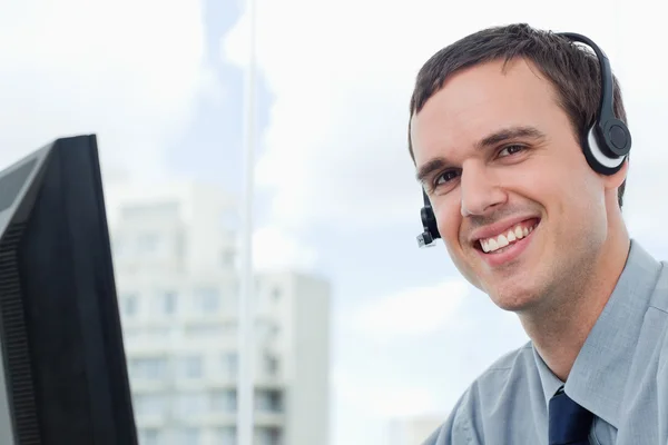 Pracownik biurowy szczęśliwy przy użyciu zestawu słuchawkowego — Zdjęcie stockowe