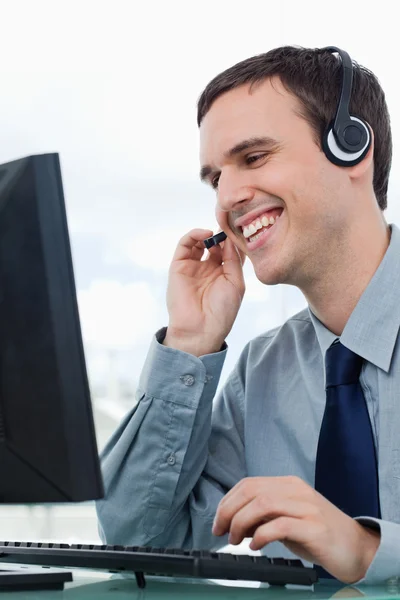 Retrato de um trabalhador de escritório sorridente usando um fone de ouvido — Fotografia de Stock