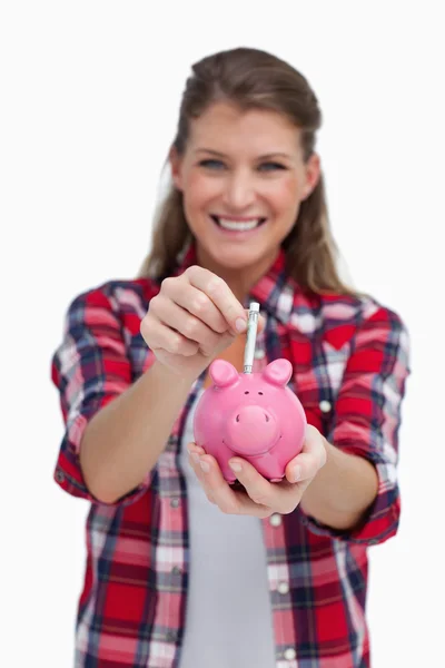 Retrato de uma mulher colocando uma nota um banco porquinho — Fotografia de Stock