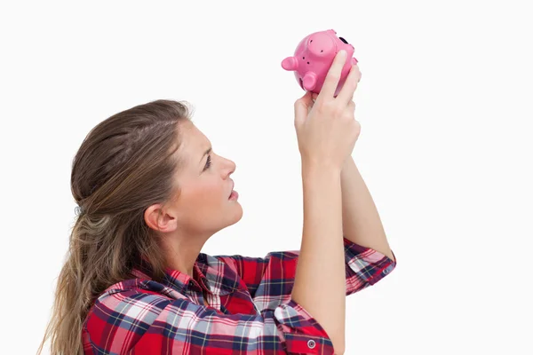 Vrouw op zoek binnen een piggy bank — Stockfoto