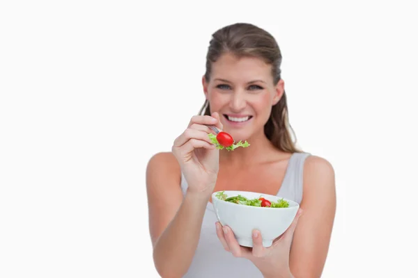 Mulher sorridente comendo uma salada — Fotografia de Stock