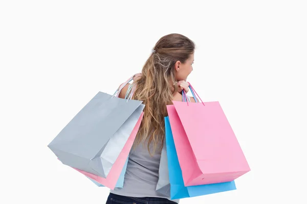 Vista trasera de una mujer sosteniendo bolsas de compras — Foto de Stock