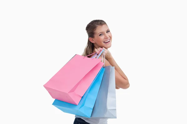 Back view of a cheerful woman holding shopping bags — Stock Photo, Image