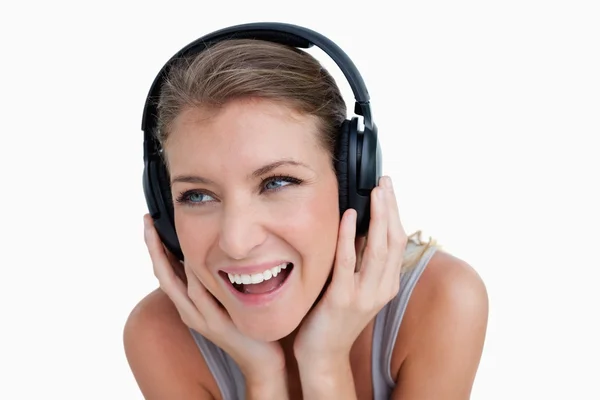Close up of a smiling woman listening to music — Stock Photo, Image