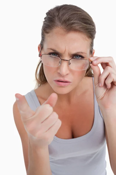 Portrait of a serious woman with glasses pointing at the viewer — Stock Photo, Image