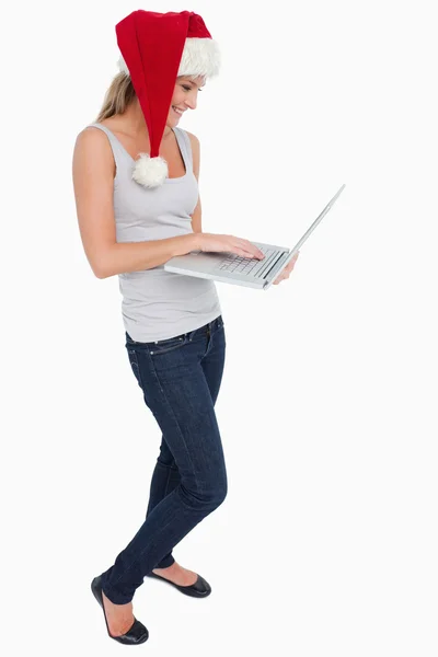 Retrato de una mujer con un sombrero de Navidad usando un cuaderno — Foto de Stock