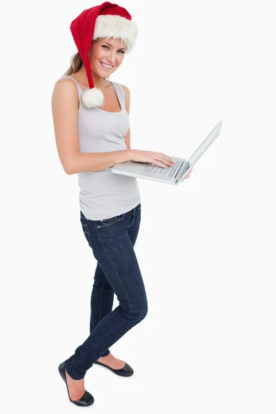 Portrait of a woman with a Christmas hat using a notebook — Stock Photo, Image