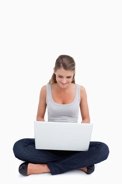 Mulher de pernas cruzadas usando um laptop — Fotografia de Stock