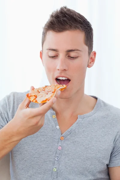Närbild av en man som han kommer att äta en bit pizza han är Stockbild