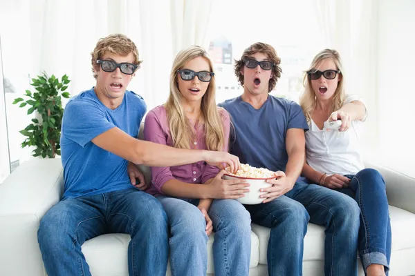 Een groep van vrienden kijken naar een enge 3D-film Stockfoto